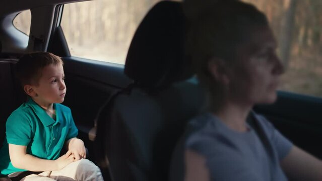 Mother and son go on a car trip together. A child in a car seat, a happy family goes on vacation together.