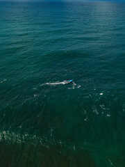 Fototapeta premium Drone photo of fishing boat in the middle of the ocean looking for fish with cloudy sky on the background