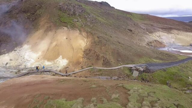 Geothermal area Krysuvik in the Reykjanes peninsula not far from Reykjavik, Iceland. People walking in small groups on the trails