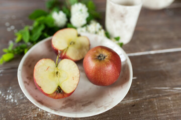 Naklejka na ściany i meble Apples on wooden plate with fresh summer flowers