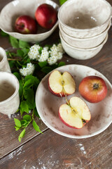 Apples on wooden plate with fresh summer flowers
