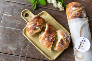 Fresh homemade baguette bread on wooden table. Healthy vegan eco food concept	