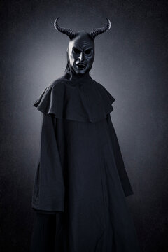 Horned demon at night over dark misty background