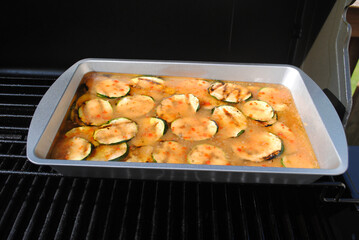 Grilled Zucchini in Italian Dressing in a Pan on a Summer Grill