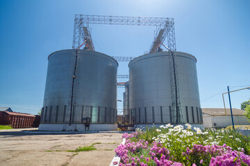 Granary elevator on blue sky background. Silos, crops storage. Cleaning, drying of grain. Ukraine international seed, wheat and corn provider
