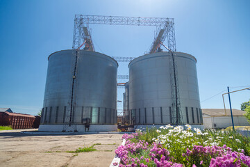Granary elevator on blue sky background. Silos, crops storage. Cleaning, drying of grain. Ukraine...