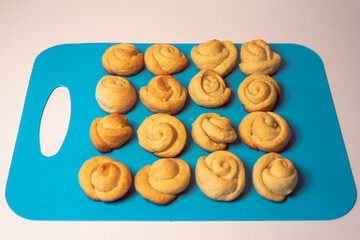 Pastries, small dough buns on a plastic tray.