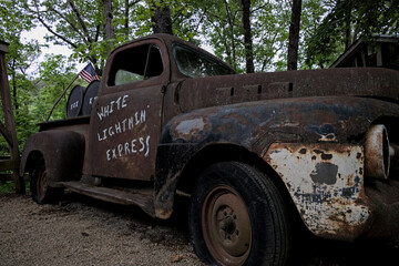 Old rusty broken down truck with oak barrels casks in back hauling moonshine an illicit alcohol liquor made illegally by people in the southern United States. - obrazy, fototapety, plakaty