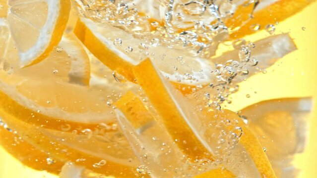 Super Slow Motion Shot of Fresh Lemon Slices Falling into Water Vortex at 1000 fps.