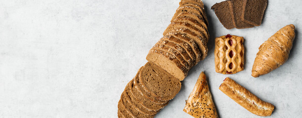 Fototapeta na wymiar Bakery - rustic crusty loaves of bread and buns on black