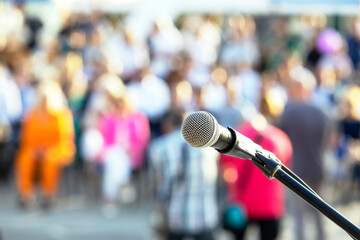 Media or publicity event, microphone in the focus against blurred people in the background
