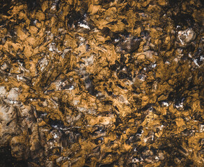 Brown wall texture. Stone background. Rock texture. Grunge Rough structure. Abstract texture. Rock surface with cracks. Rock pile. Paint spots.