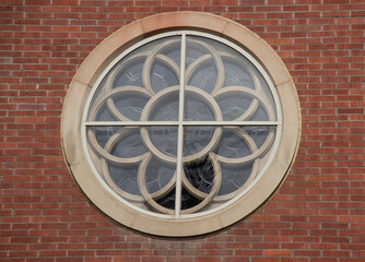 Round Church Window with Geometric Flower Design in Brick or Masonry Wall