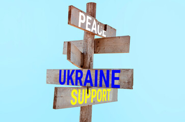 Wooden road sign with words peace, Ukraine, support, hunger 