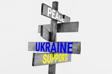 Wooden road sign with words peace, Ukraine, support, hunger 