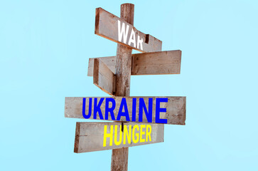 Wooden road sign with words peace, Ukraine, support, hunger 