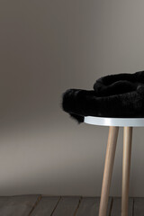 Fabric on a chair near a light gray wall, space for text. Vertical photo