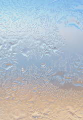 A background image of ice on a window, with sky, clouds and land refelcted through it. 