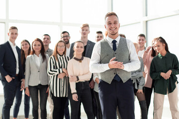 smiling young man standing in front of his colleagues