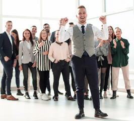 smiling young man standing in front of his colleagues