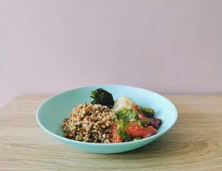 Boiled buckwheat and vegetable salad on a wooden table