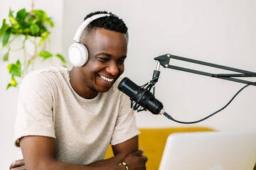 Young african content creator man streaming live podcast from home studio - obrazy, fototapety, plakaty