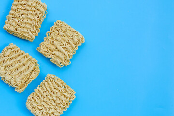 Dried instant noodles on blue background.