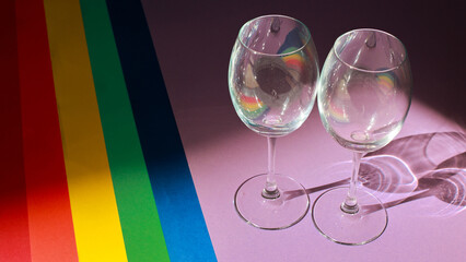LGBT Pride Flag with two glasses. Colored paper backgrounds are laid out in LGBT Flag Colors....