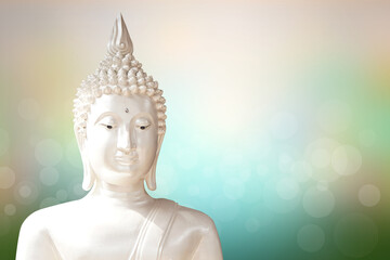 Buddha statue. background blurred flowers and sky with the light of the sun.