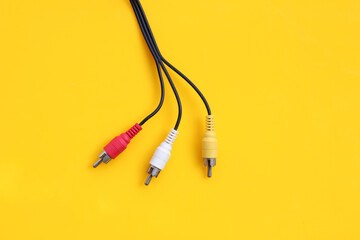Audio and video cables on yellow background