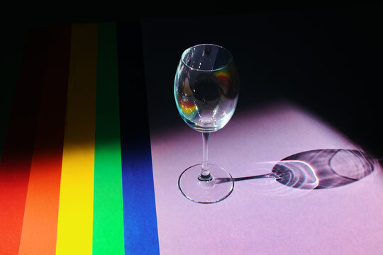 LGBT pride flag with a glass. Colored paper backgrounds are laid out in LGBT Flag Colors. Celebration concept.