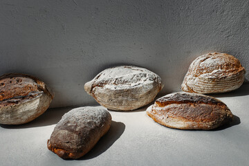 Culinary background with wholemeal loaves of bread on gray.