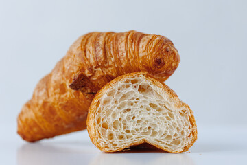 Half of croissant isolated on a background of a whole croissant on a white background