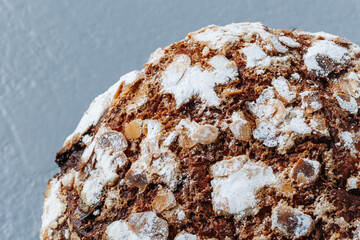 Italian panettone with powdered sugar. Sweet Easter cake on a gray background.