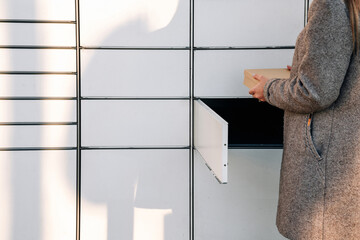Post locker. Delivery automat terminal and hands with parcel courier box. Parcel delivery, pickup point with lockers, hand with parcel, contactless pack delivery.