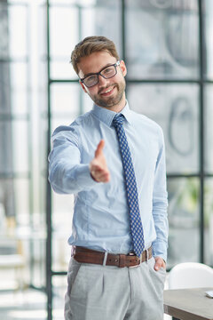portrait confident smiling businessman offering hand for handshake