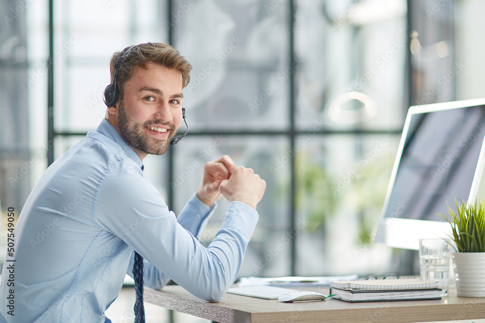 Wall mural man with headphones and laptop working in office