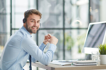 Man with headphones and laptop working in office