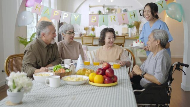 Group of Asian senior people having birthday party at home, celebrating birthday at retirement home with friends