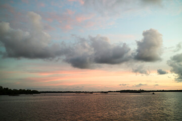 Sunset over the river. Silhouette of small boats at sunset.