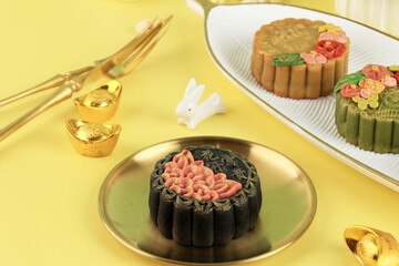 Black Mooncake on Light Yellow Background with Gold Dusting  Concept Moon Cake on Mid Autumn Festival.