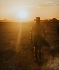 A cowboy walks into the desert