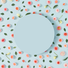 Fototapeta na wymiar Creative pattern made of pink flowers and leaves with writing space on blue pastel background minimal concept. Flat lay