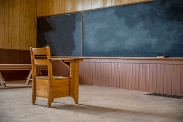 A single wooden desk in an abandoned, rural one-room schoolhouse on the prairies in Saskatchewan