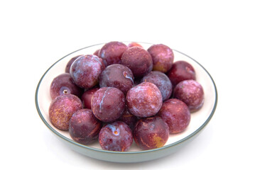 Purple plums on white background