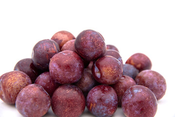 Purple plums on white background