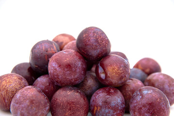 Purple plums on white background