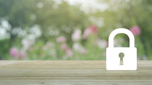 Padlock flat icon on wooden table over blur pink flower and tree in park, Technology internet security and safety online concept