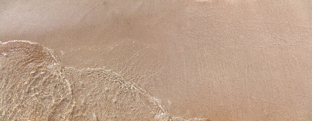 Sea water touch wet sand, copy space. Summer holiday in Greece. Empty sandy beach top view.