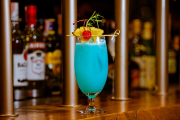 Glass of Blue Hawaii Cocktail on Wooden Bar Counter